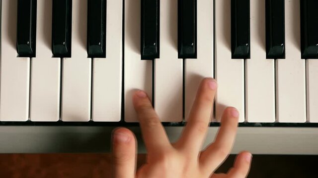 Children's fingers play the keys of the piano. teaching a child to play a musical instrument. Musical education