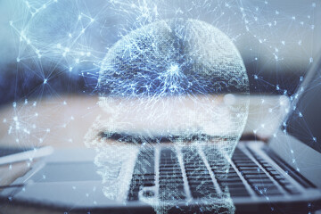 Double exposure of table with computer and brain hologram. Data innovation concept.