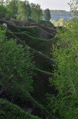 Fototapeta premium Young grass on the hills framing the floodplain of the Sylva River. Spring in the foothills of the Western Urals. It's a nice sunny day.