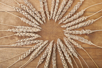 Уши пшеницы и чаша зерна пшеницы на коричневом деревянном фоне