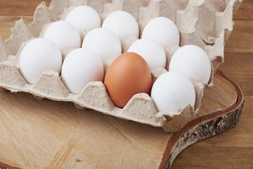 Крупным планом вид сырых куриных яиц в яйцеклетке на белом деревянном фоне