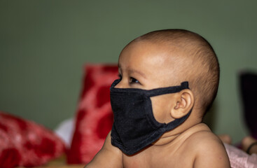 child wearing black mask for protection against infections with background blur