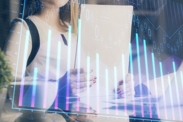 Double exposure of hands making notes with forex chart huds. Stock market concept.