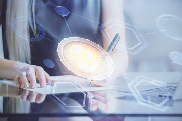 Cryptocurrency hologram over woman's hands writing background. Concept of blockchain. Double...
