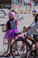 Fototapeta premium Group of kids in custume dresses sitting on a bike looking at an electric bicycle and a scooter.