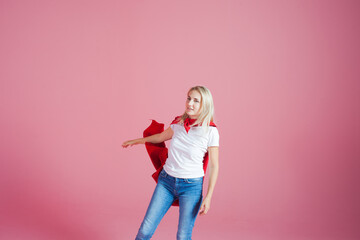 flying superhero. Funny young woman in the image of a superhero to the rescue. Pink background