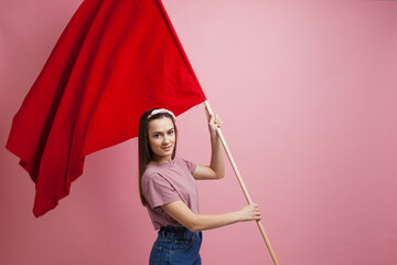 activist and revolutionary, young woman with a red flag on a pink background.