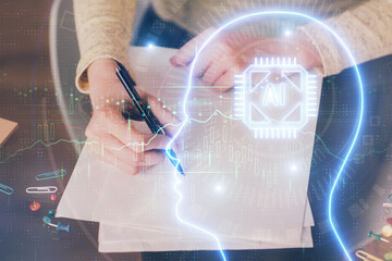 Double exposure of writing hand on background with brain hologram. Concept of learning.