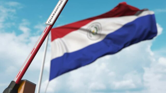 Barrier gate with QUARANTINE sign being open with flag of Paraguay as a background. Paraguayan Lockdown end