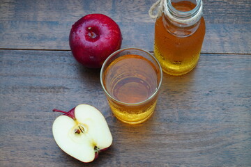 Apple juice in a glass And red ripe apples On an old wooden bar