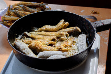 Frying Gobius sobitis (goby fish) in a pan. Cooking fried fish in a pan. Mediterranean cuisine, junk food, tasty snacks for beer concept