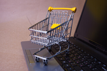 E-Commerce. Online shopping, shopping cart on laptop keyboard.