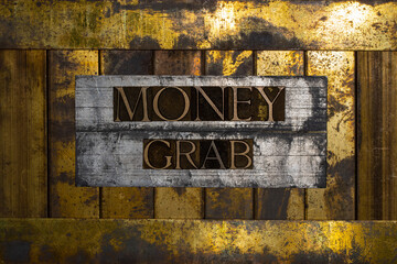 Photo of real authentic typeset letters forming Money Grab text on vintage textured silver grunge copper and gold background