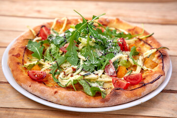 pizza with fresh vegetables on the wooden background