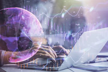 Double exposure of market chart with man working on computer on background. Concept of financial...
