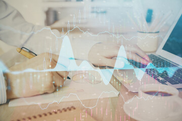 Multi exposure of stock market graph with man working on laptop on background. Concept of financial analysis.