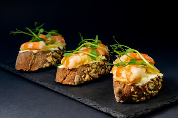 fresh bruschetta with shrimp, cheese, ham and microgreens