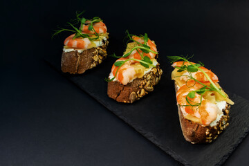 fresh bruschetta with shrimp, cheese, ham and microgreens