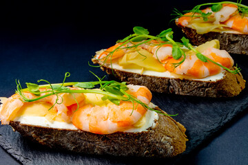 fresh bruschetta with shrimp, cheese, ham and microgreens