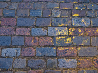 Reflection from a street lamp on wet paving stones.