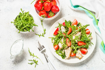 Green salad with chicken, strawberry and arugula.