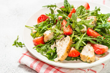 Green salad with chicken, strawberry and arugula.