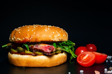 burger with chop, steak, cheese, salad on a black background