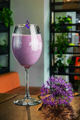 blueberry cocktail in a glass on a high leg