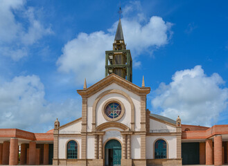 Fototapeta na wymiar Le Francois, Martinique - September 18, 2018: Catholic Church of Saint Michael, Eglise catholique de Saint-Michel. Blue sky, white clouds. Copy space