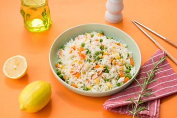 A plate of white rice with vegetables on a stylish trending orange background, Asian food