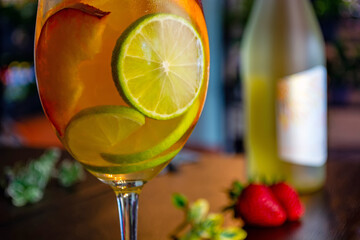 white wine cocktail with slices of peach lime and orange