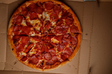 Pizza. spicy pizza on a cardboard box. Tasty pizza with bacon, salami and cheese.Background pizza pepperoni.