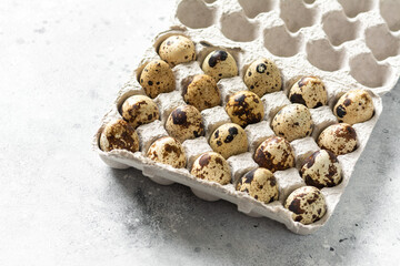 Eggs on a tray on the kitchen table. Quail eggs on a culinary background. Concept of preparation for baking.