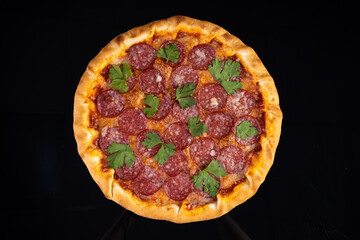 pizza with sausage on a black background for the restaurant menu