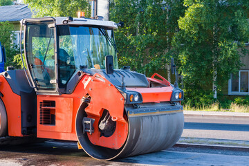 Orange road rollers for laying asphalt during construction, paving