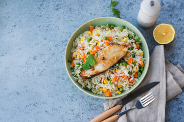 Rice with vegetables and fish steak, copy space, top view