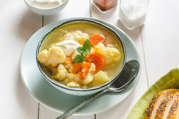 Cauliflower soup with vegetables in a bowl.