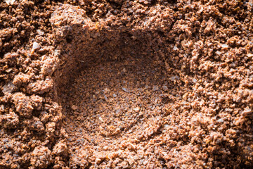 background in the form of a young black instant coffee texture and hole. Closeup top view