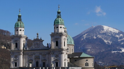Blick über Salzburg mit Dom, Stift St. Peter und schneebedecktem Berg im Hintergrund bei...