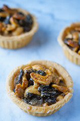 Butter tart with dried fruit on the marble background.