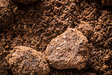 background in the form of a young black instant coffee texture and piece of rock. closeup top view