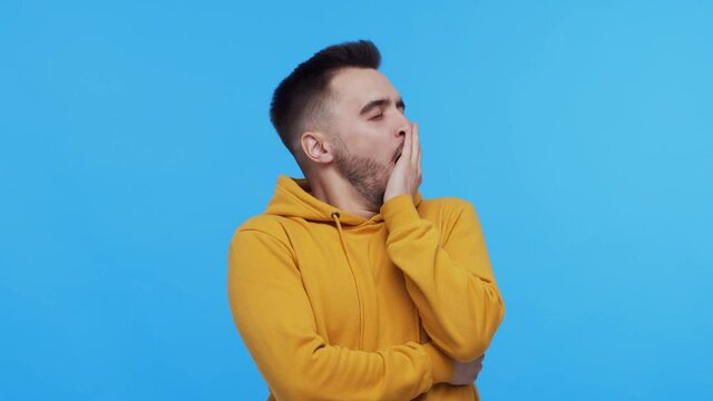 Expressive young man over vibrant background. Studio portrait of borred person.