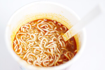 Instant noodle dish in a cup isolated on white background, close up.
