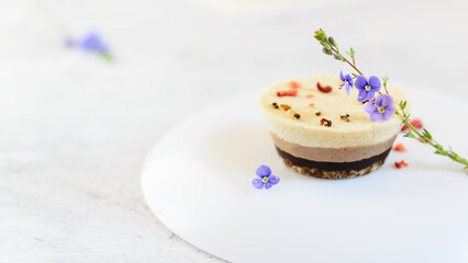 Cashew cake decorated with flowers and sublimated berries. Horizontal orientation, copy space.