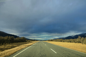 Driving in autumn on the wonderful scenic Mount Cook Road under the endless sky with destination Lake Pukaki in Canterbury, New Zealand