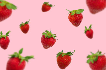 Colorful pattern of falling strawberries on pastel pink background