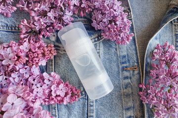 Mock up of transparent bottle of Intimate lubricant gel for branding and label and lilac flowers...