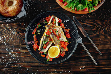 Two fillets of fish seabass with rich tomato and garlic sauce