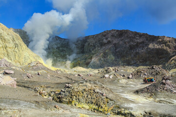 Landscape of White Island, an active volcano off the coast of New Zealand. Groups of tourists are...