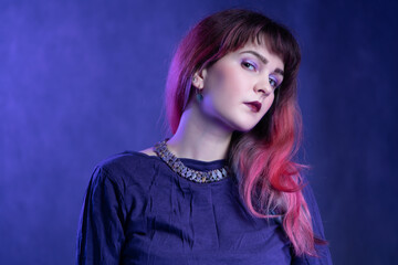 Beautiful girl in studio portrait in violet-blue image